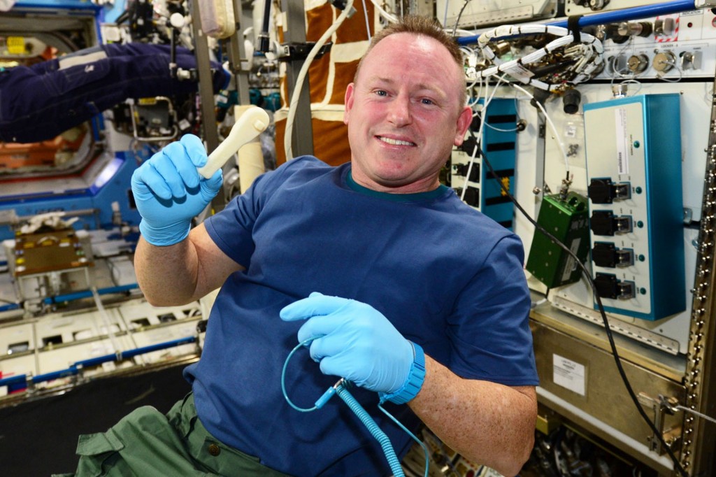 El astronauta Barry Wilmore con la llave inglesa que fue fabricada en el espacio.